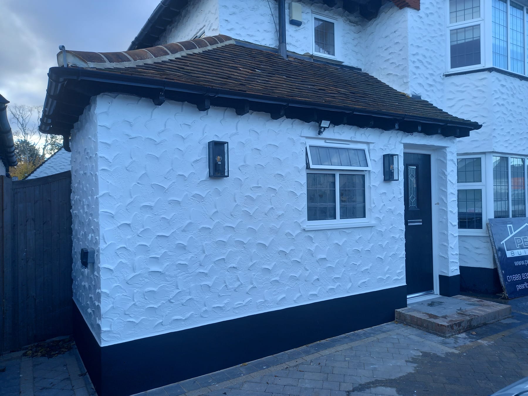 white detatched home with built on side extension