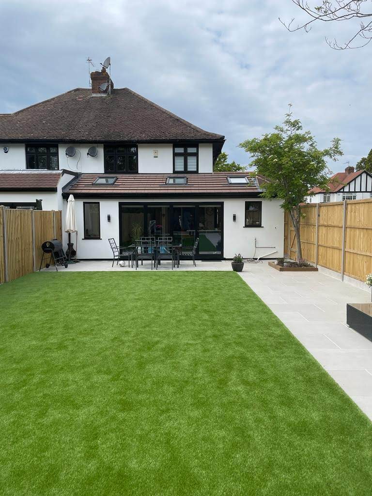 white home with garden patio and garden furnature with green grass